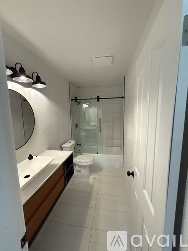 A bathroom with a toilet, sink, and shower.
