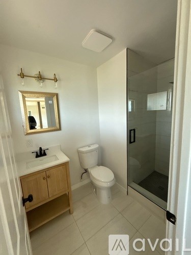 A bathroom with a toilet, sink, and mirror.