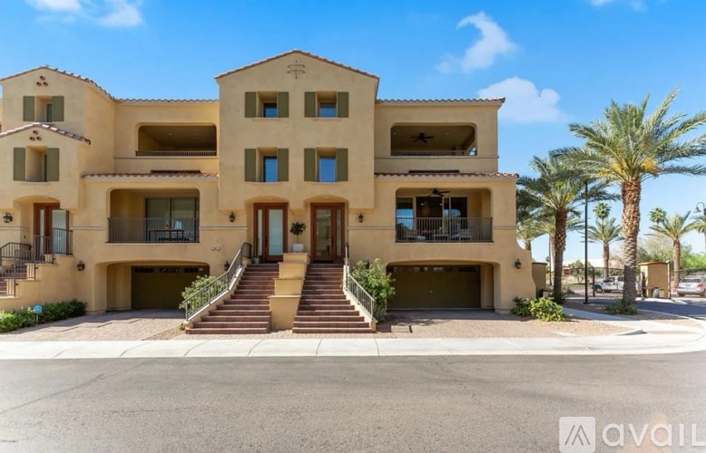 A large beige house with a balcony and a garage door.
