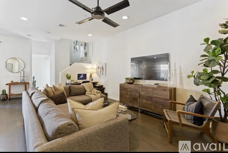 A living room with a long couch and a ceiling fan.