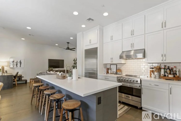 A modern kitchen with white cabinets and a large island.