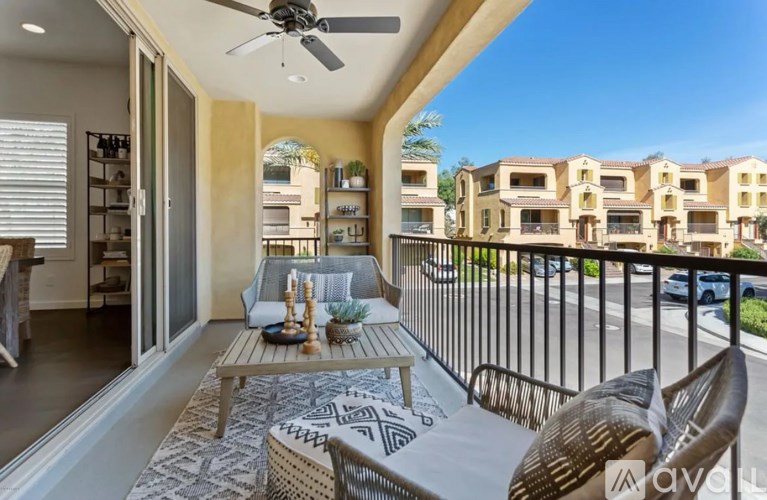 A balcony with a table and chairs overlooking a row of houses.