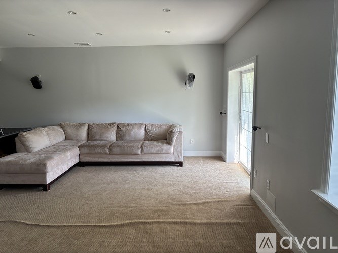 A living room with a beige sofa and a carpet.