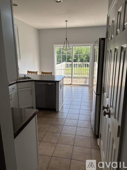 A kitchen with white cabinets and a black countertop.