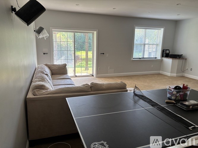 A living room with a grey sofa and a black table.
