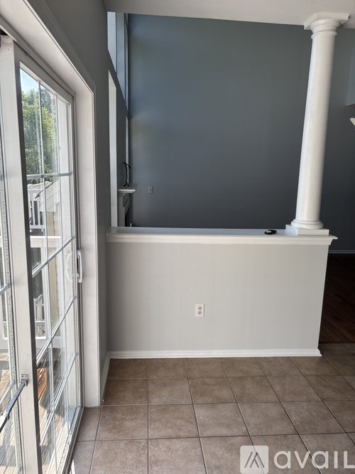 A room with a white column and tiled floor.