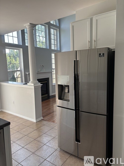 A kitchen with a refrigerator and a fireplace.