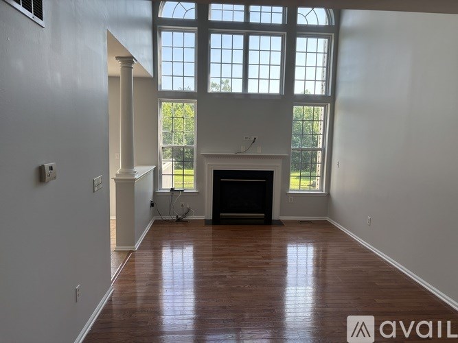 A living room with a fireplace and a large window.