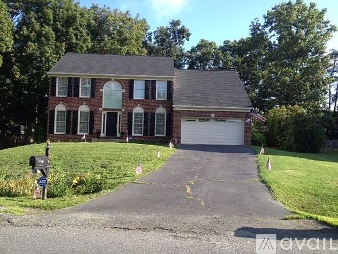 A brick house with a driveway in front.