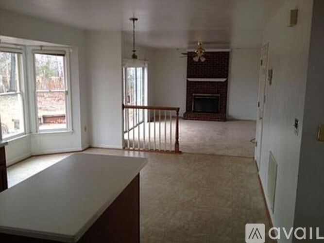 A living room with a fireplace and a ceiling fan.