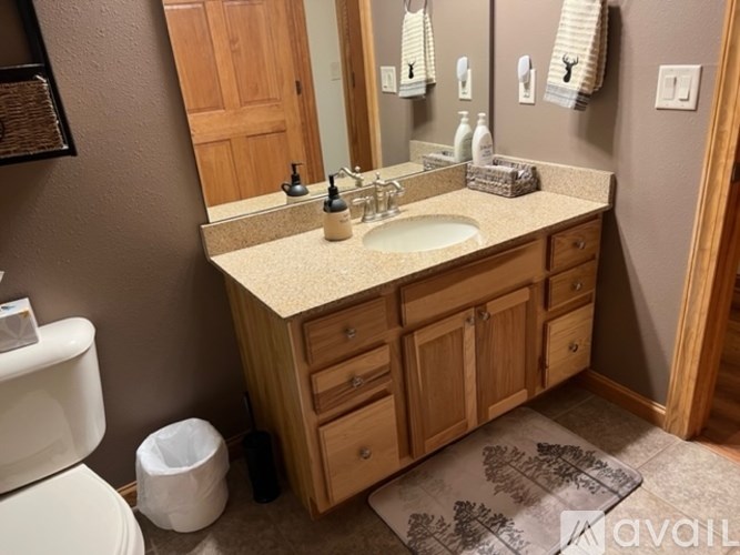 A bathroom with a sink, toilet, and mirror.