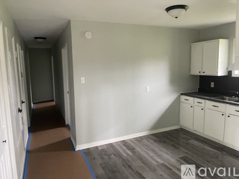 A kitchen area with a sink, cabinets, and a countertop.