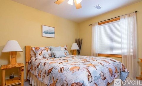 A bedroom with a bed, a lamp, and a picture on the wall.