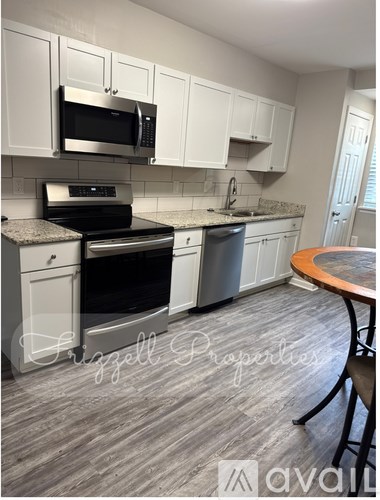 A kitchen with white cabinets and a wooden table.