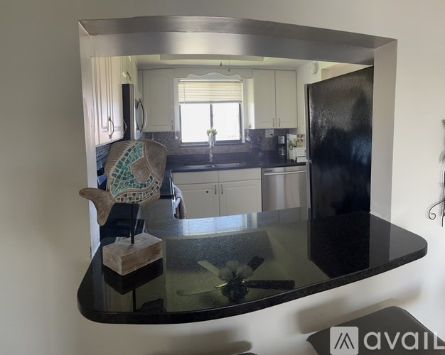 A modern kitchen with a glass table and a view of the dining area.