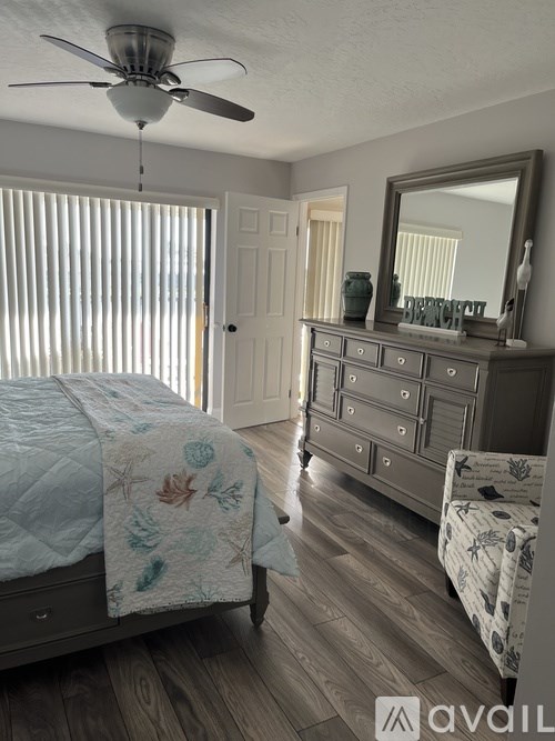 A bedroom with a bed, dresser, and mirror.