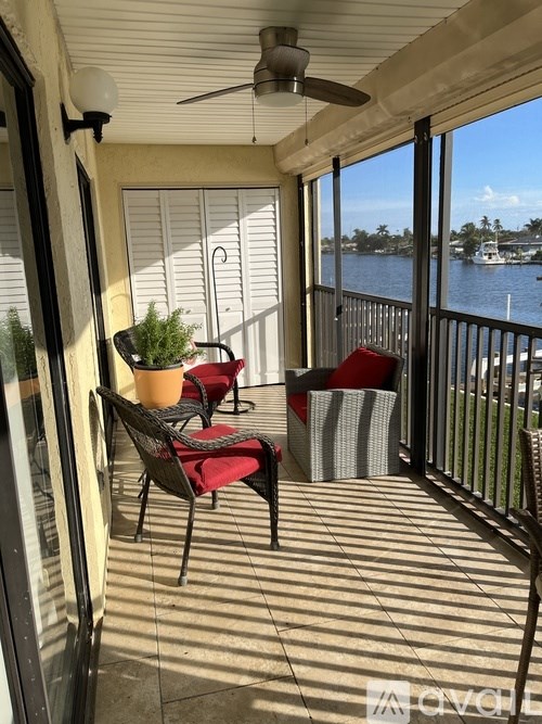 A balcony with a chair and a table with a potted plant on it.