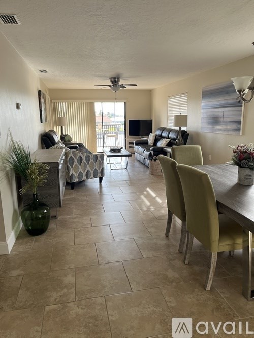 A living room with a couch, chairs, and a television.