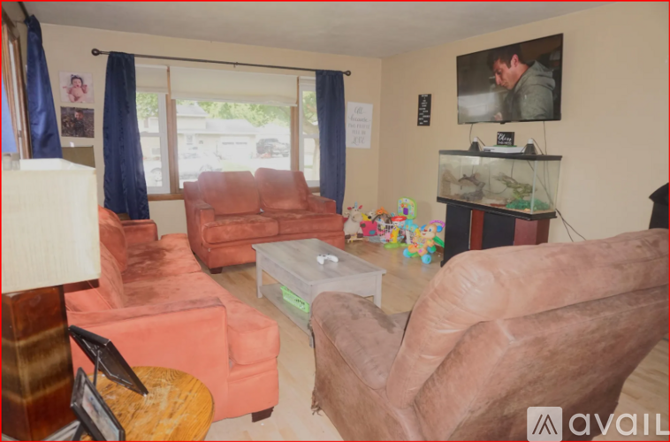 A living room with a couch, chair, and a fish tank.