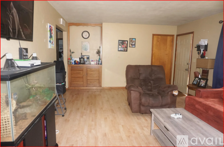 A living room with a brown recliner and a glass aquarium.