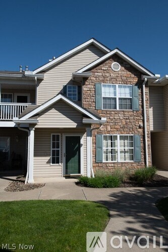 A house with a stone facade and green shutters is for sale.