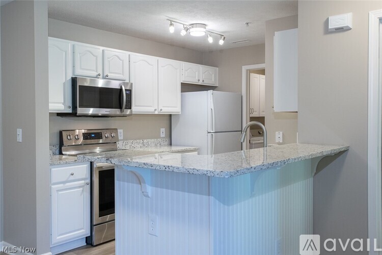 A kitchen with white cabinets and a granite countertop.
