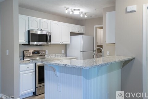 A kitchen with white cabinets and a granite countertop.