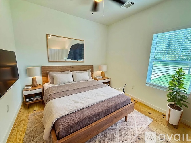 A bedroom with a large bed and a flat screen TV mounted on the wall.