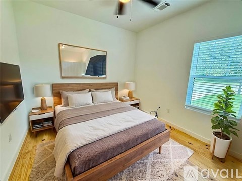 A bedroom with a large bed and a flat screen TV mounted on the wall.
