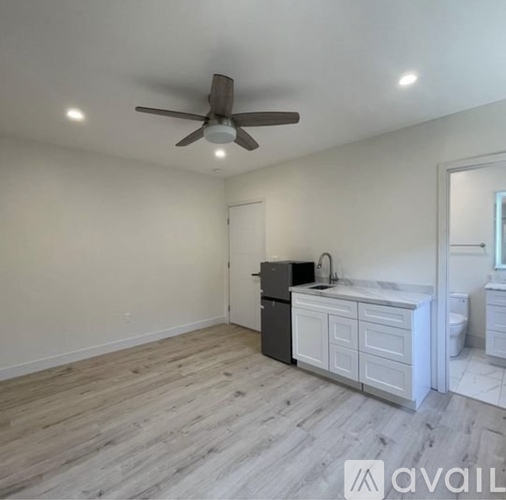 A room with a ceiling fan and wooden flooring.