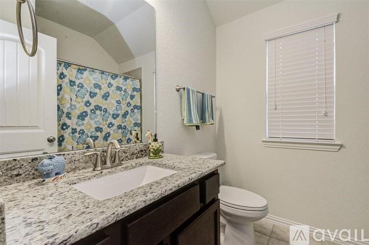 A bathroom with a toilet, sink, and shower.