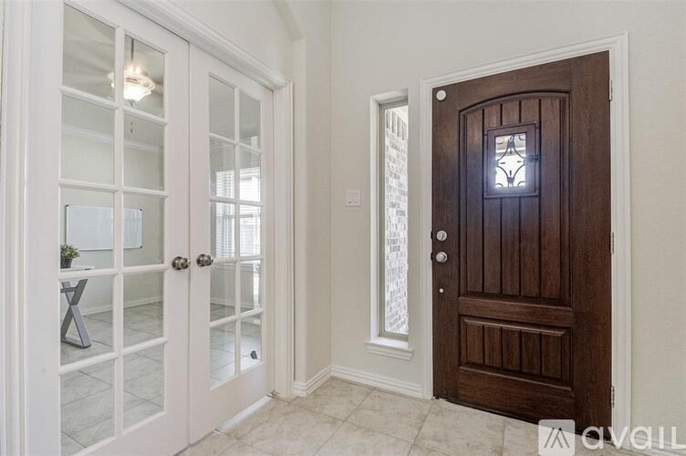 A white door with a glass panel is open to a hallway.