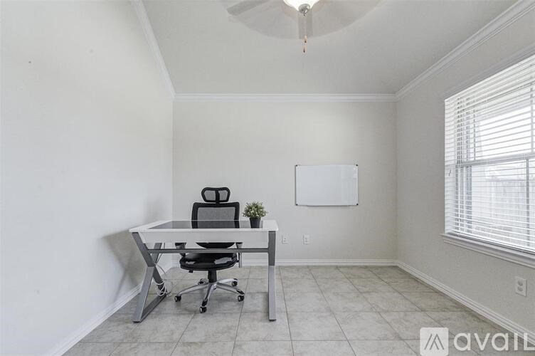 A room with a white desk and a black office chair.