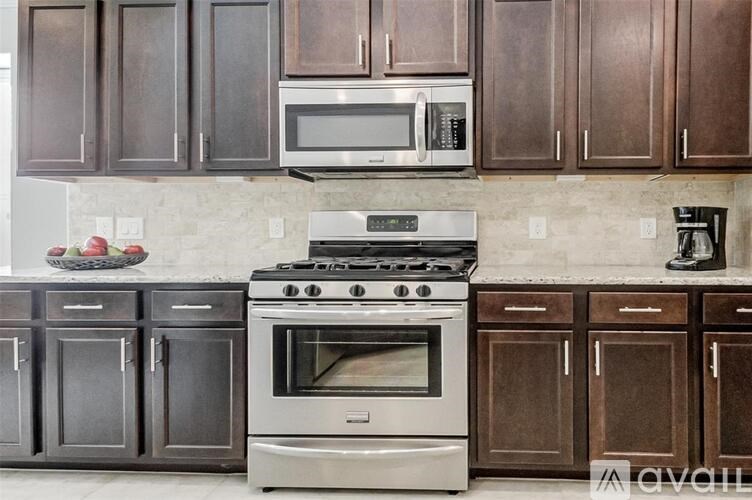A kitchen with a stove, oven, and microwave.
