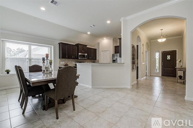 A kitchen with a table and chairs in the foreground and a hallway in the background.