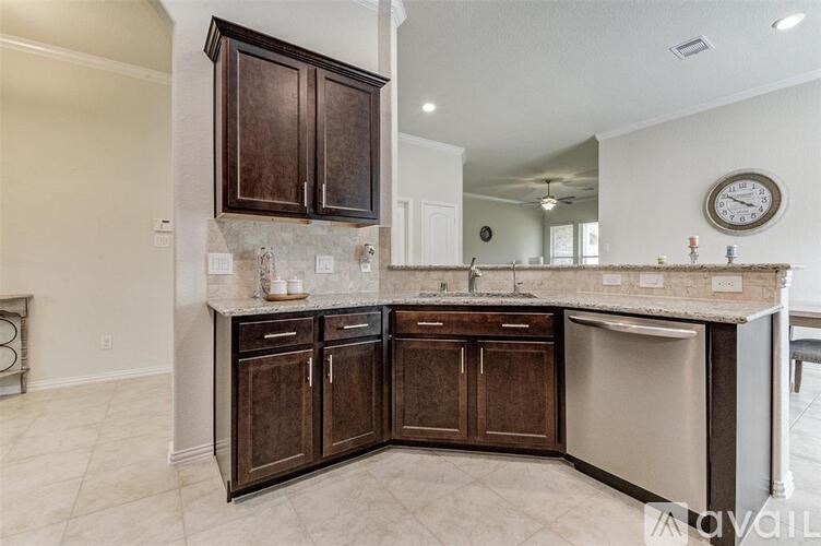 A kitchen with brown cabinets and a marble countertop.