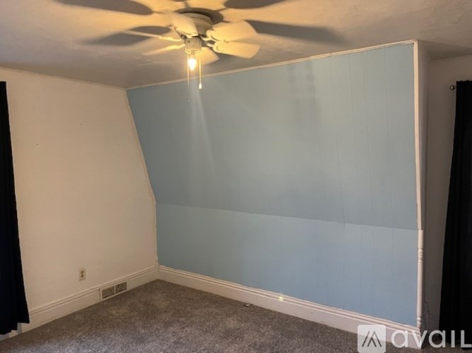 A room with a ceiling fan and a light hanging from it.