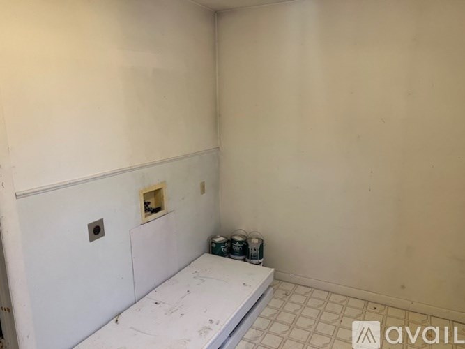 A room with a white wall and a white floor with a hole in the wall.