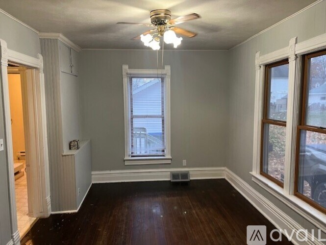 A room with a ceiling fan and a window.