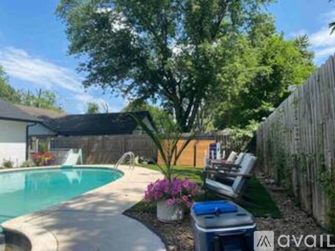 A backyard with a pool and a wooden fence.