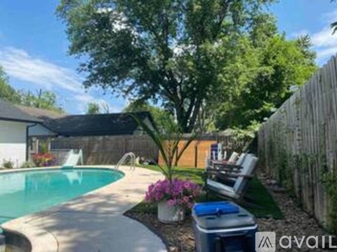 A backyard with a pool and a wooden fence.