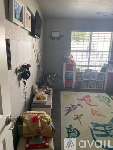 A room with a rug on the floor and a wall hanging.