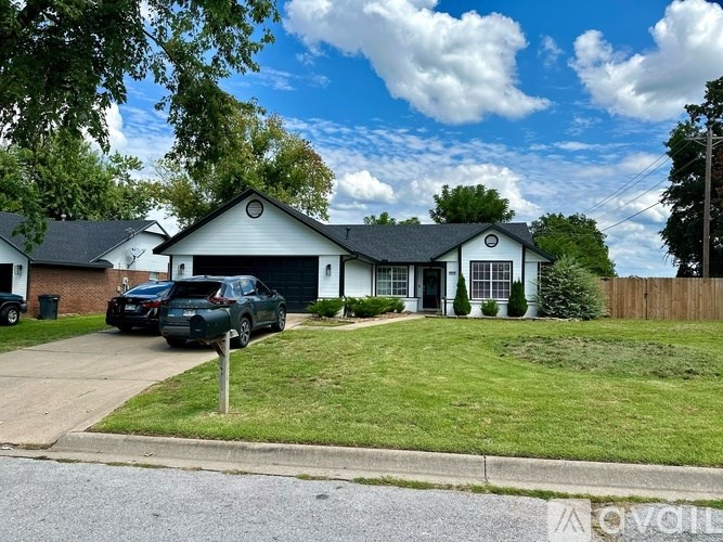 A white house with a black car parked in front.