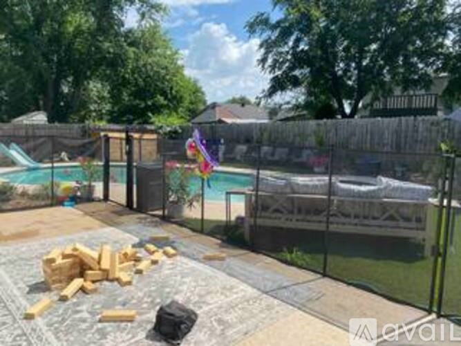 A backyard with a pool and a fence.