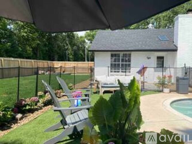 A patio with a table and chairs is covered by a white umbrella.