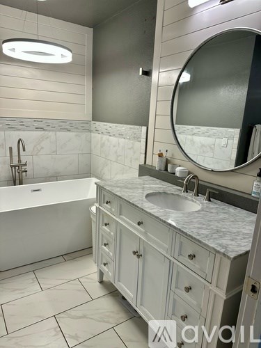 A bathroom with a white tub and sink.
