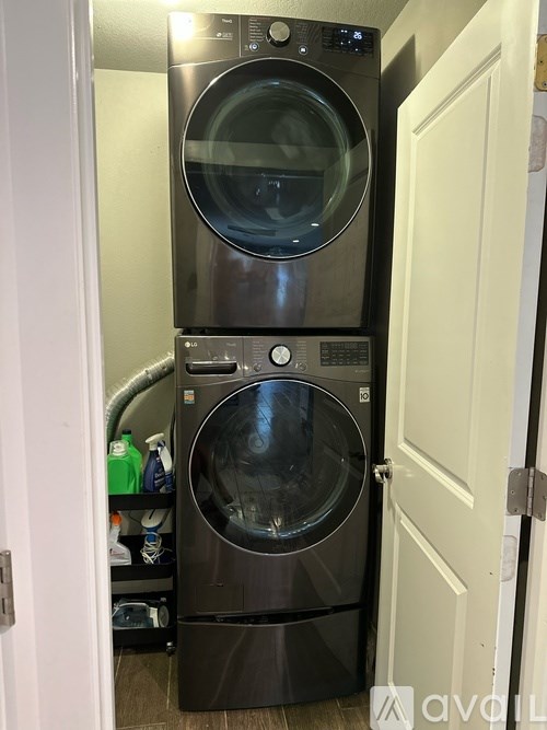 A stack of two front loading washing machines in a small laundry room.