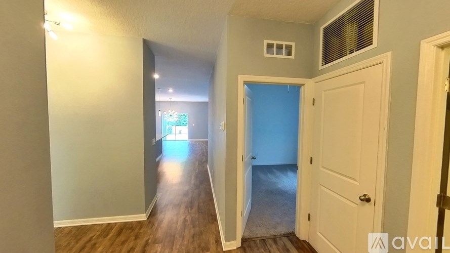 A hallway with a door on the right and a window in the distance.