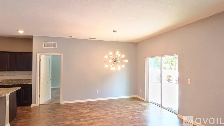 A large, empty room with a chandelier and a window.