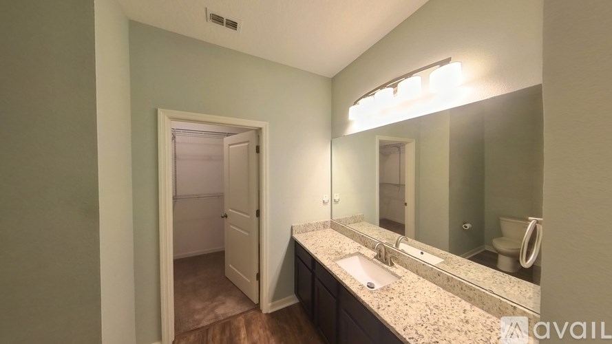 A bathroom with a sink, mirror, and toilet.